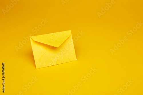 Yellow color paper office envelope for greeting or invitation with copy space isolated on the bright solid fond plain yellow background