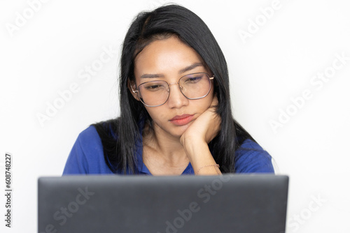 Thoughtful apathic woman working on laptop with head lean on hand photo