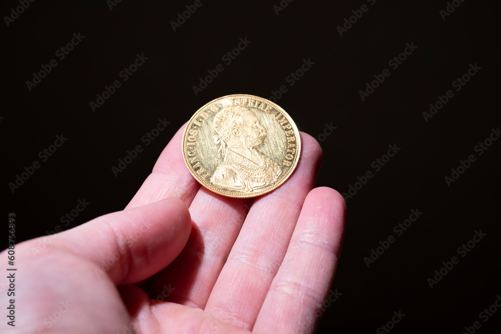 Fototapeta premium Austrian four ducats on US dollars. Investments in investment coins. The concept of buying gold. investment in gold.