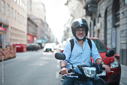 adult man on a moped in the city