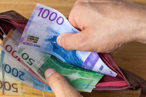 Fotografie Taking money out of wallet, Norwegian crowns, Financial and economic concept, Ho