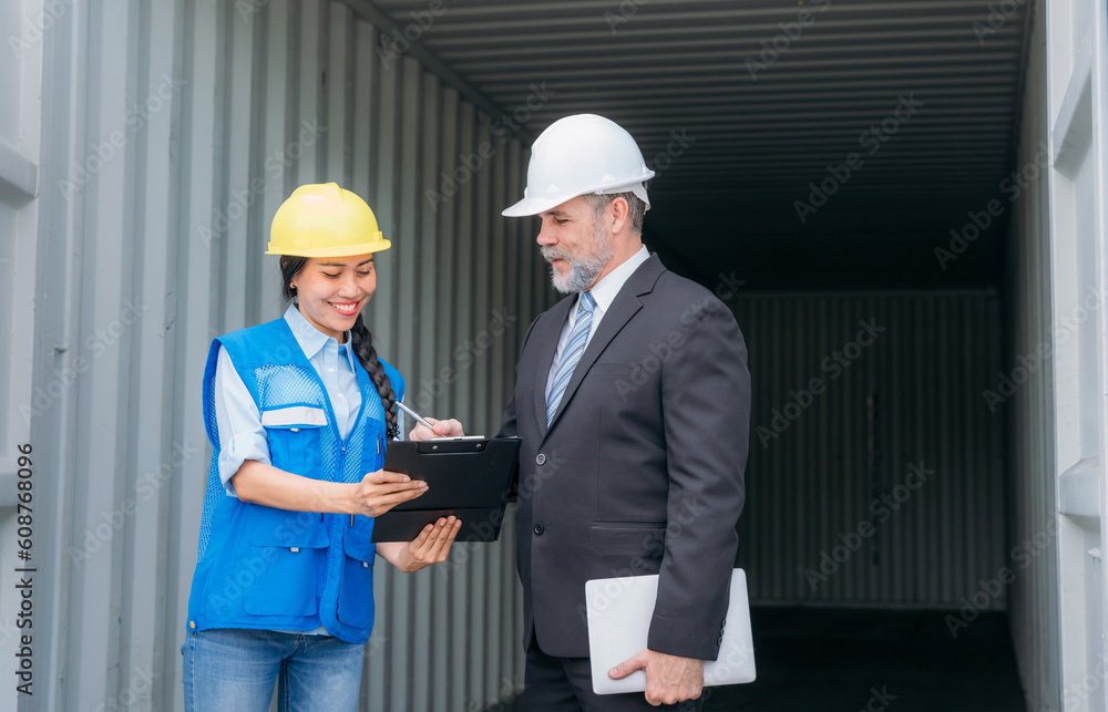 Businessman, Engineer or foreman talking and checking inventory or task details at container yard warehouse., Logistics concept inside the shipping, import, and export industries. Businessman, Engineer or foreman talking and checking inventory or task details at container yard warehouse., Logistics concept inside the shipping, import, and export industries.