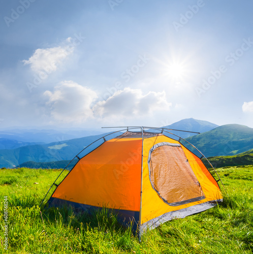 closeup orange touristic tent stay in green mountain at the sunny day, mountain travel scene