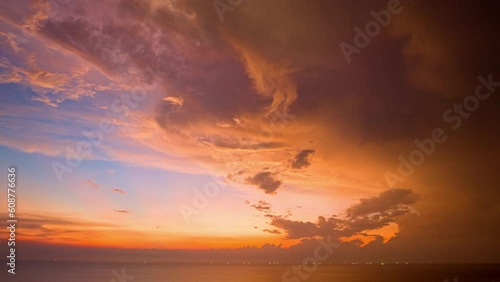 .Watching the sky in time lapse reveals the ever changing movement of the clouds, .the gradual changes in light as the time passes..The orange clouds moved and changed their color to red. photo