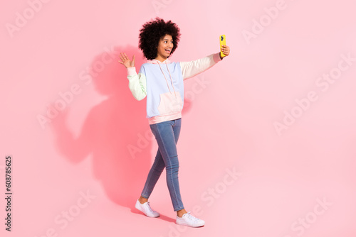 Full length photo of friendly sweet small kid wear sweatshirt video call talk modern device isolated pink color background