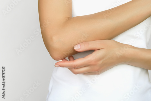 woman applying moisturizer on elbow skin, care for dry elbow skin