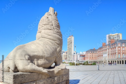Photo of a majestic lion statue standing proudly in front of a beautiful building in Mar del Plata, Argentina