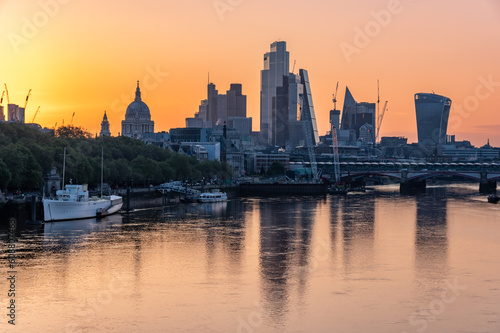 London City skyscrapers and St Paul's Cathedral dome over River Thames on colorful morning