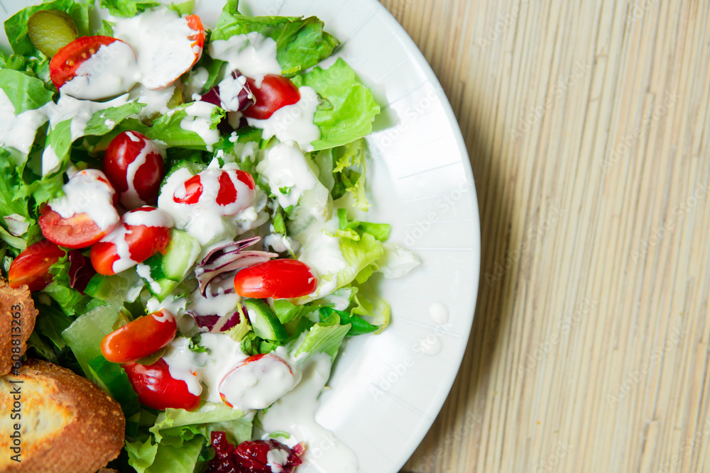 close up of a healthy delicious salad with tomatoes, cheese, chicken, vegetables and baguette. A light, healthy meal rich in protein. Caesar salad close up of a healthy delicious salad with tomatoes, cheese, chicken, vegetables and baguette. A light, healthy meal rich in protein. Caesar salad