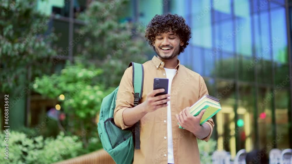 Handsome smiling university student with backpack and books in hands ...