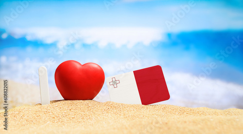I love Malta. Flag of Malta on the beach with a red heart. vacation and travel concept.