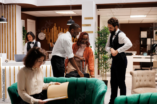Bild auf Leinwand Hotel concierge assisting guests in lobby, helping with check in process at reception front desk