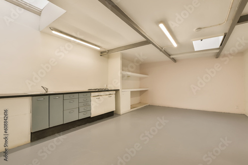 an empty room with white walls and grey flooring  there is no one person in the room to be seen