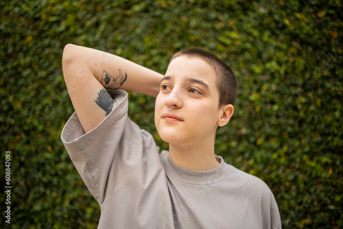 Portrait of Latin transgender generation z person with the short hair looking away. 
