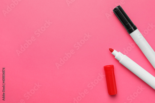Bright color markers on pink background, flat lay. Space for text