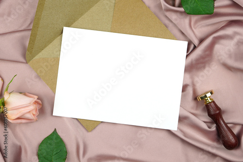 Vertical landcape 5x7 invitation wedding program stationery suite card mock-up styled with vintage wax seal, and pink rose, on a crushed dusty rose satin background.