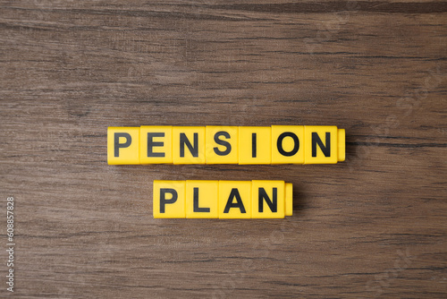 Yellow cubes with phrase Pension Plan on wooden table, flat lay