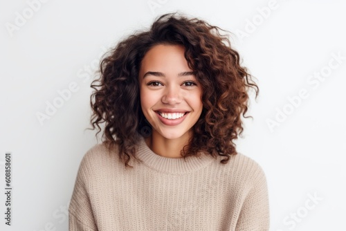 Portrait of beautiful young woman with curly hair smiling and looking at camera © Robert MEYNER