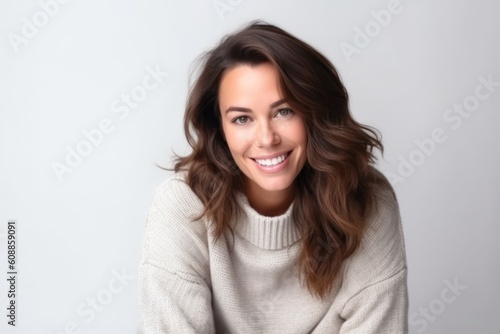 Portrait of a beautiful young woman smiling on a white background.