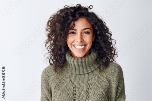 Portrait of a beautiful young woman with curly hair smiling at camera