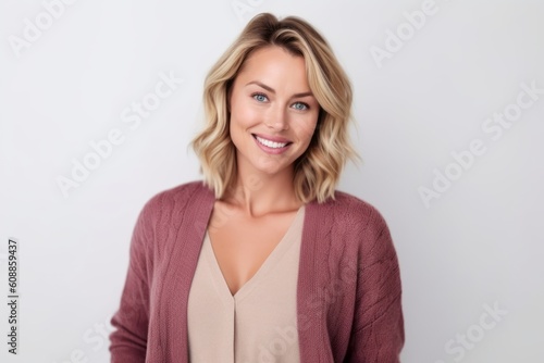 Portrait of a beautiful young woman smiling at the camera while standing against white background