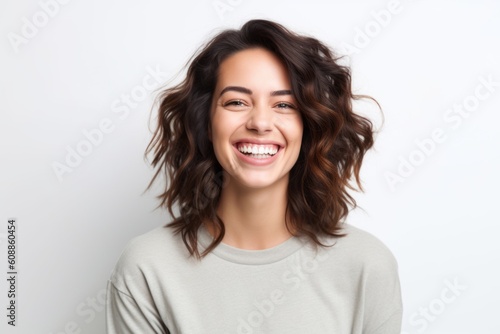 Portrait of a happy young woman laughing and looking at camera over white background