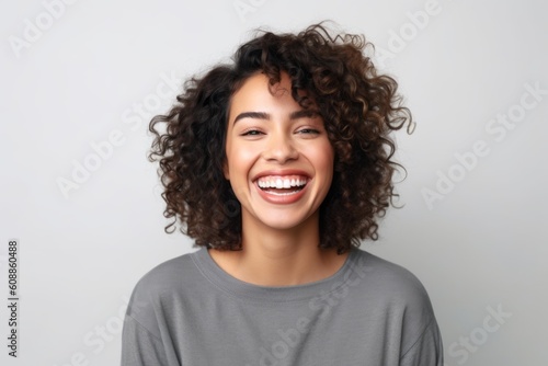 Portrait of a beautiful young african american woman laughing against white background © Robert MEYNER