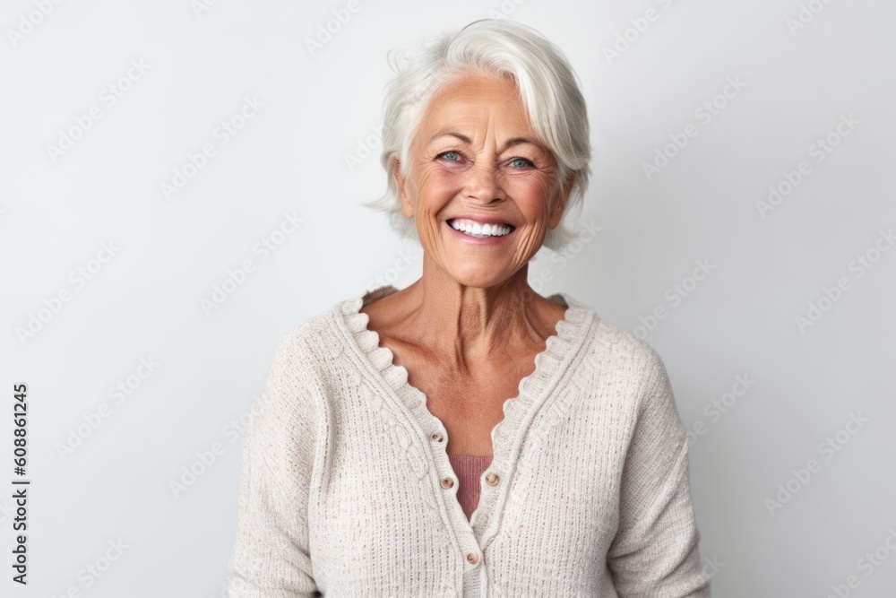 Portrait of a smiling senior woman looking at camera against white background Portrait of a smiling senior woman looking at camera against white background