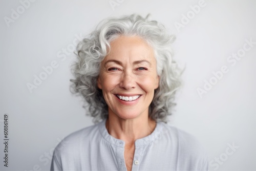 Portrait of a smiling senior woman with grey hair on a white background