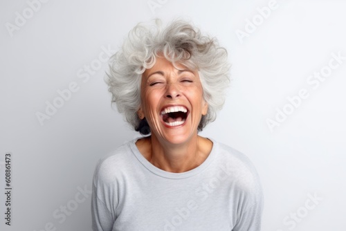 Close up portrait of a happy senior woman laughing on white background.