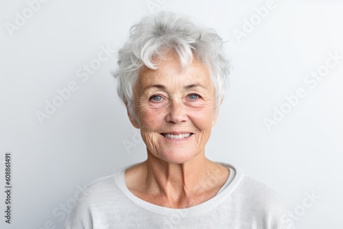 Portrait of a smiling senior woman with grey hair on white background