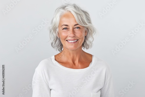 Portrait of a smiling senior woman looking at camera over white background
