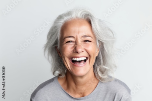 Close up portrait of a happy senior woman laughing isolated on a white background