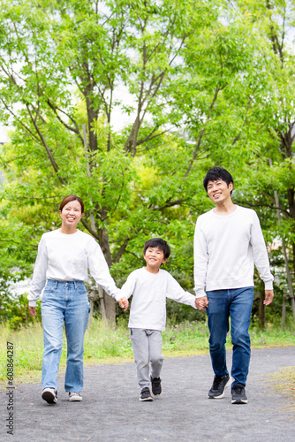 新緑の公園を散歩する日本人の家族