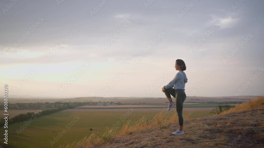 Caucasian female runner standing and warming up in preparation for a jogging run Caucasian female runner standing and warming up in preparation for a jogging run