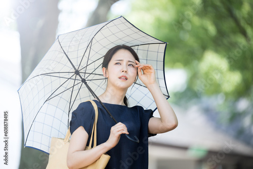Preventing UV rays and heat stroke Beautiful hot Asian woman looking up with parasol　
