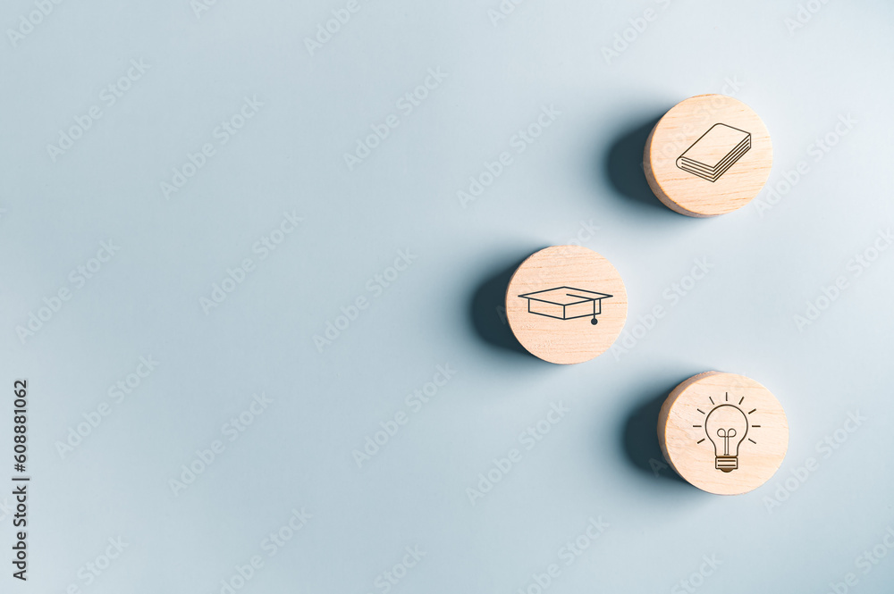 Education graduated icon on wooden block with mortarboard Graduation cap book lightbulb on blue background. Students getting ready to return to college arrive first time in school. Off to University Education graduated icon on wooden block with mortarboard Graduation cap book lightbulb on blue background. Students getting ready to return to college arrive first time in school. Off to University