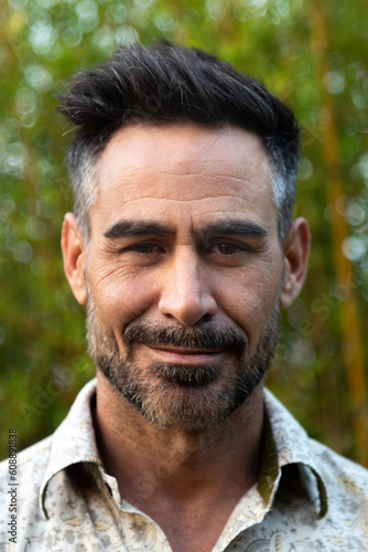 Vertical headshot of middle age white man with beard in nature.