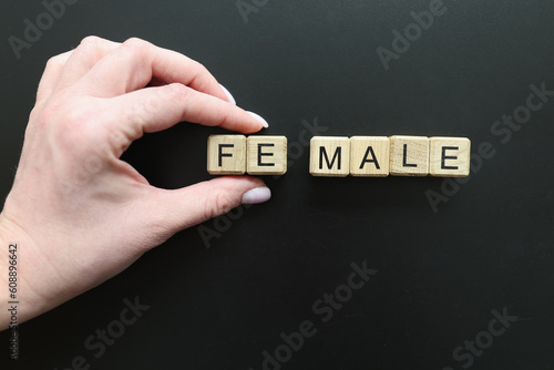 Hand of woman adding cubes with letters FE to change word