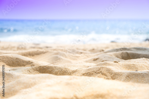 Beach sand background for summer vacation concept. Beach nature and summer seawater with sunlight light sandy beach Sparkling sea water contrast with the blue sky.