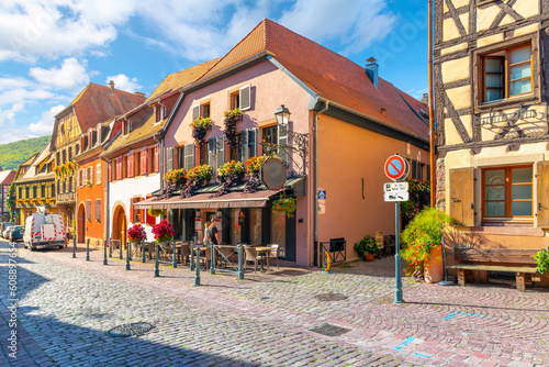 A picturesque cobbled street of shops and restaurants in the historic medieval Alsatian village of Kaysersberg-Vignoble France, near Colmar along the wine route.