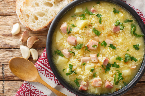 Cossack Ukrainian rich soup kulish made of millet, potatoes, onions with bacon close-up in a plate on the table. horizontal top view from above photo