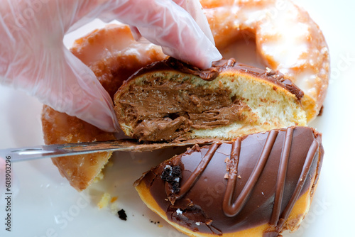 bagel cut in half and spread with cream cheese, placed on a plate with a knife and bowl of cheese next to it and on a dark background. High quality photo photo