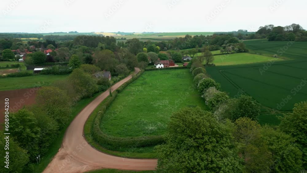 Cinematic drone video reveals the beauty of Brinkhill village, UK. Red tiled rooftops, brick and thatched houses, and rural farmlands showcased.