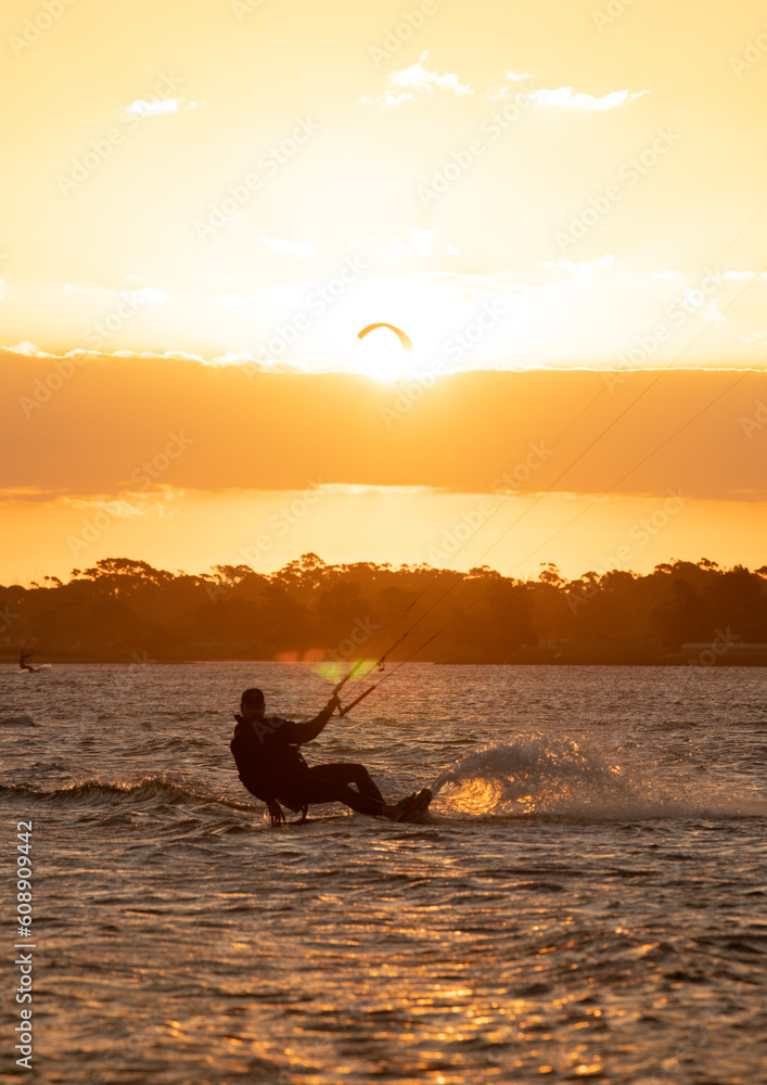 Kit surfer gliding on water at Sunset