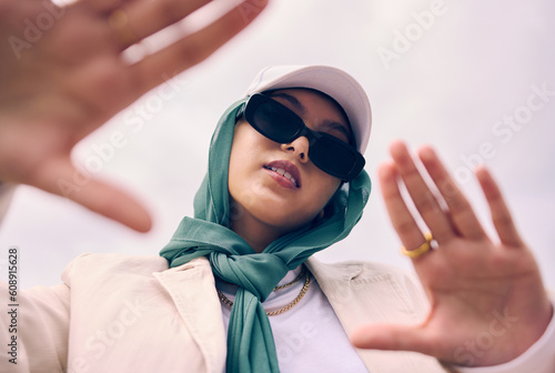 Photography Low angle portrait, woman and city for muslim fashion with gen z aesthetic, streetwear and sky background