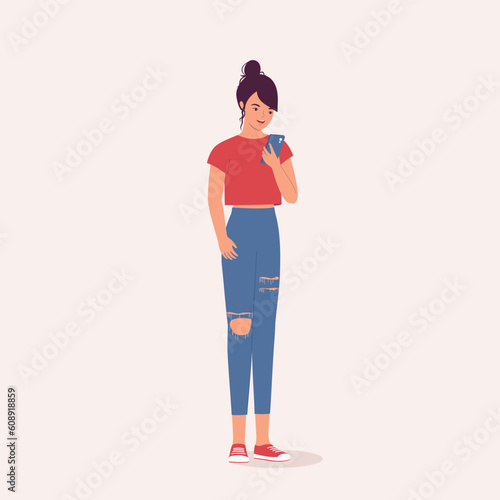 One Smiling Teenage Girl In Ripped Jeans Using Her Mobile Phone While Standing. Digital Native. Full Length. Flat Design Style, Character, Cartoon.