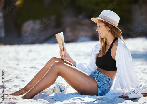 Book, beach and woman reading on summer holiday, vacation or travel in nature outdoor. Relax, novel and person at sand coast for calm break, peace and freedom for enjoying quality alone time in Bali. #608920862