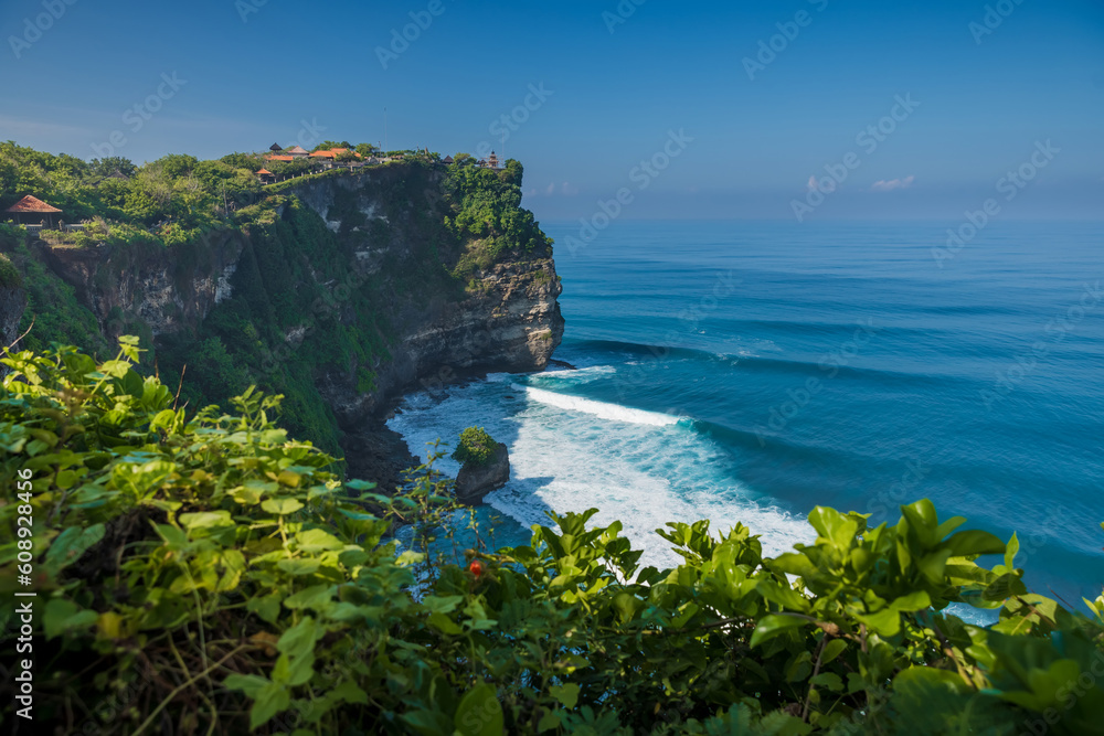 Scenic cliff and ocean with waves in Uluwatu, Bali. Popular place with balinese temple