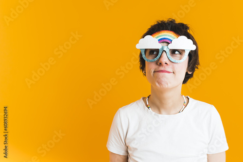 Young woman goofing around and wearing silly glasses with clouds and a rainbow. Fun concept. High quality photo © PoppyPix